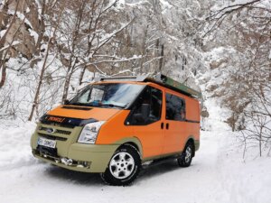 Orange van on a snow-covered road in Norway